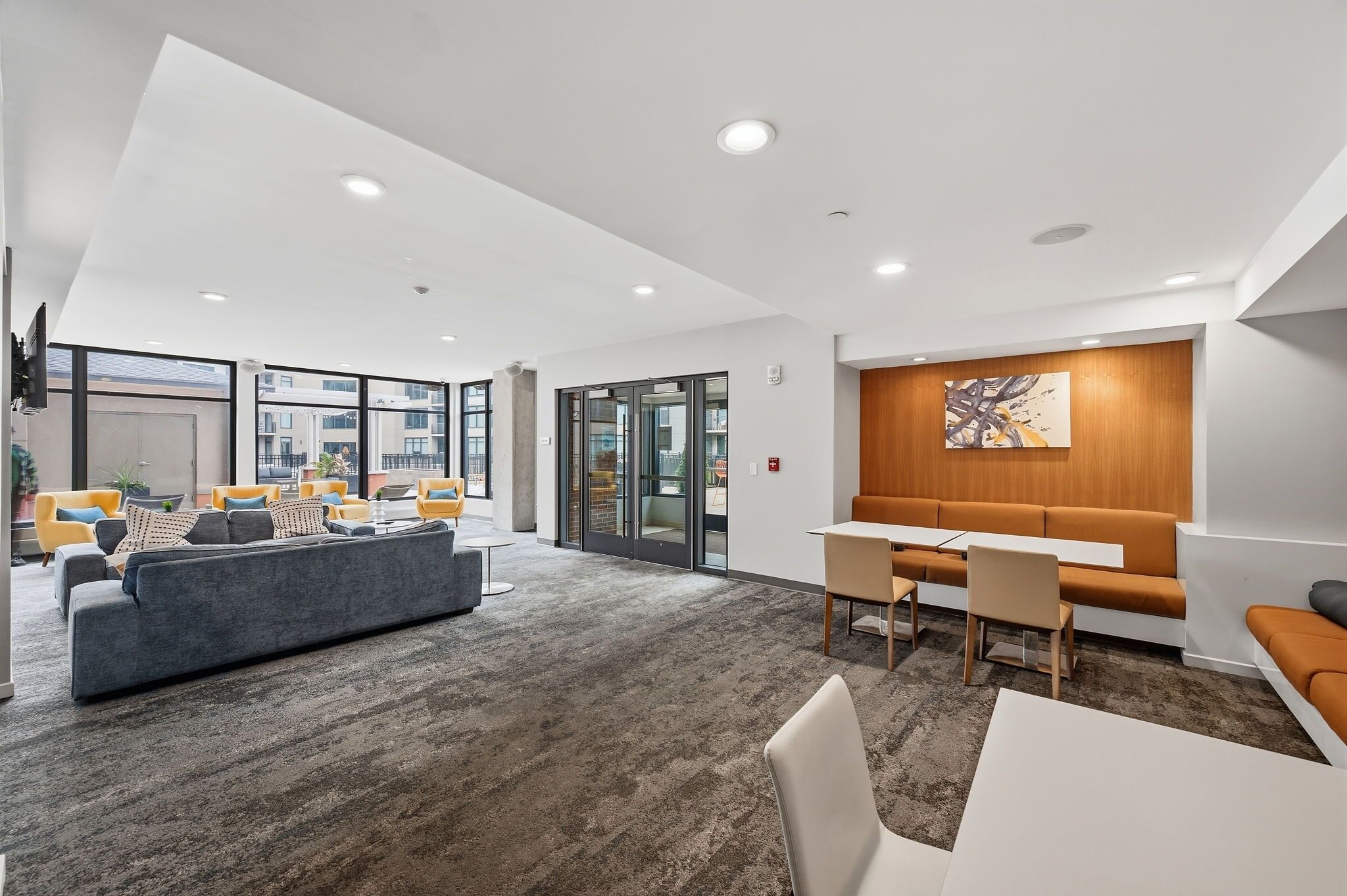 A modern interior with a seating area, a wooden accent wall, and a large window.