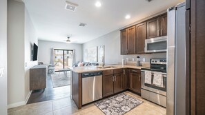 A modern kitchen with stainless steel appliances, wooden cabinets, and a central island.