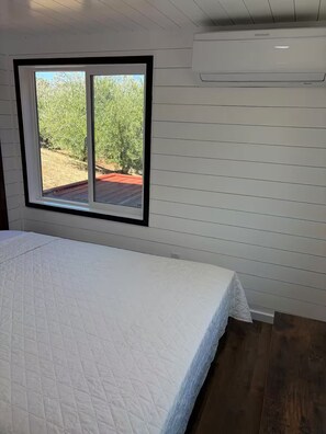 A bedroom with a bed, a window, and an air conditioning unit. - Nectarine Cabin @ Vinyard Winery, 4 Adults, 2 Kids, WiFi, AC, Fallbrook (Fallbrook)