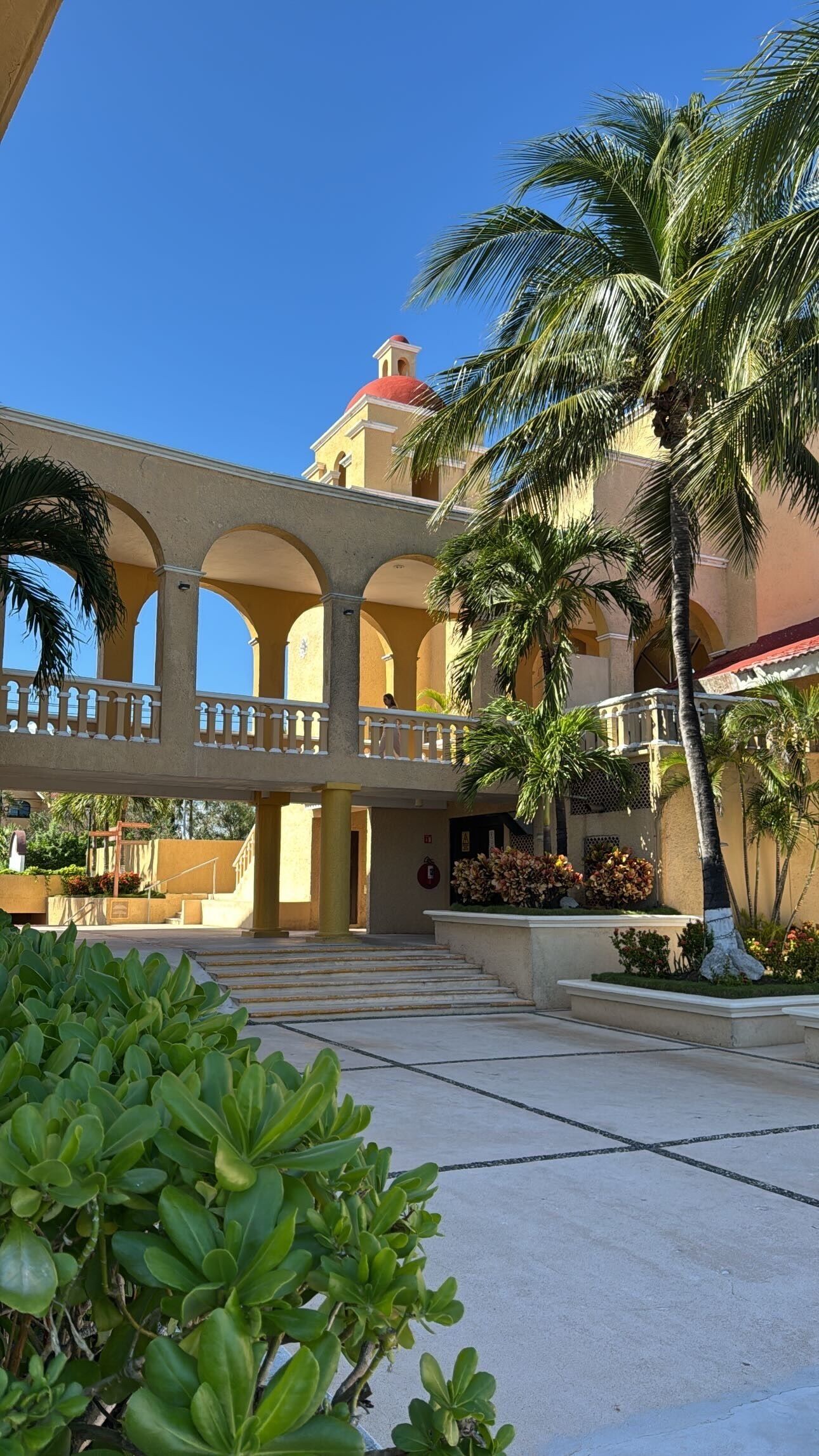 A building with a red dome and a balcony with white railings.