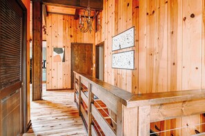 A wooden interior with a wooden floor, a bench, and a chandelier. - Rockwell Ridge | Estate with Afton Mountain Views (Afton)