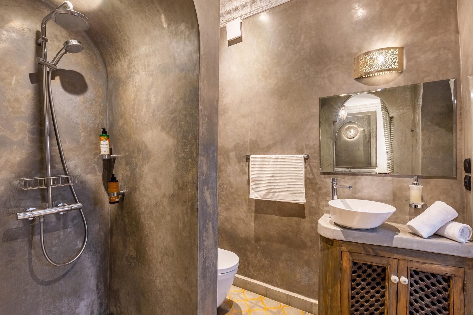 Un bagno con doccia, servizi igienici, lavandino e specchio.