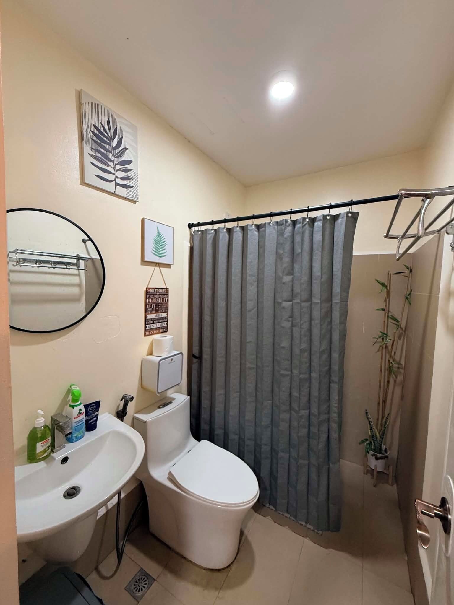 A bathroom with a toilet, sink, and shower curtain.