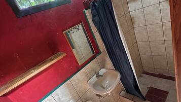 Un baño con inodoro, lavamanos y ducha.