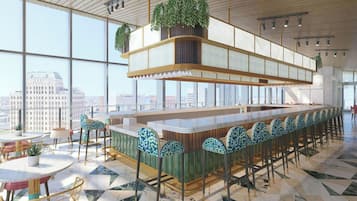 Un espace bar moderne avec un plafond haut, de grandes fenêtres et une vue sur la ville.