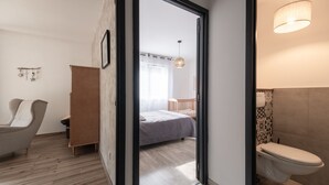 A modern bedroom with a bed, a chair, and a wooden wardrobe.