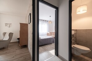 Une chambre à coucher moderne avec un lit, une chaise et une armoire en bois.