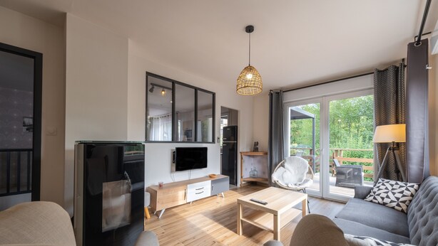A modern living room with a sofa, a coffee table, a TV, and a dining area with a table and chairs.
