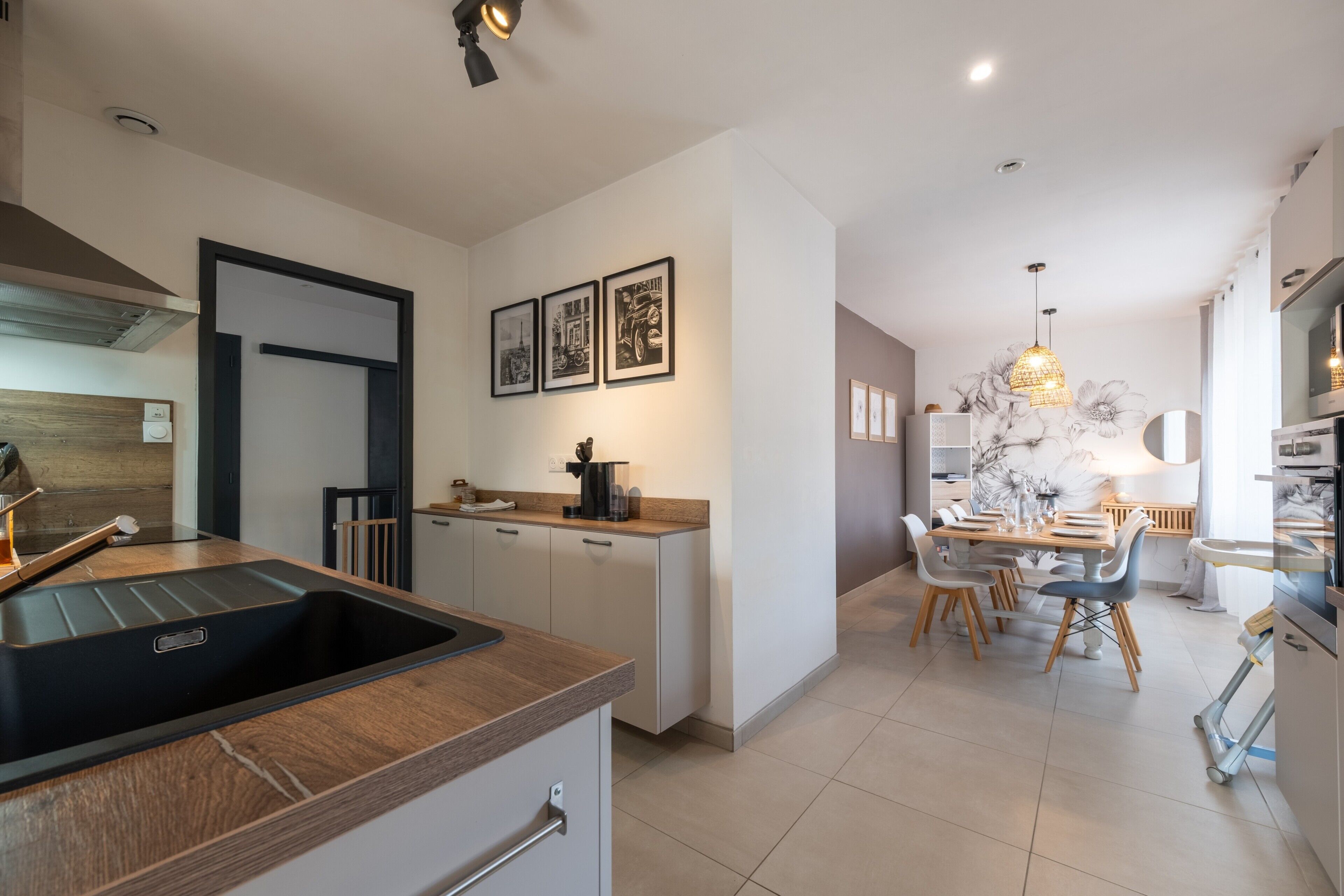 A modern kitchen with a built-in sink, a dining area with a table set for four, and a kitchen island.