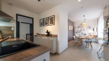 A modern kitchen with a built-in sink, a dining area with a table set for four, and a kitchen island.