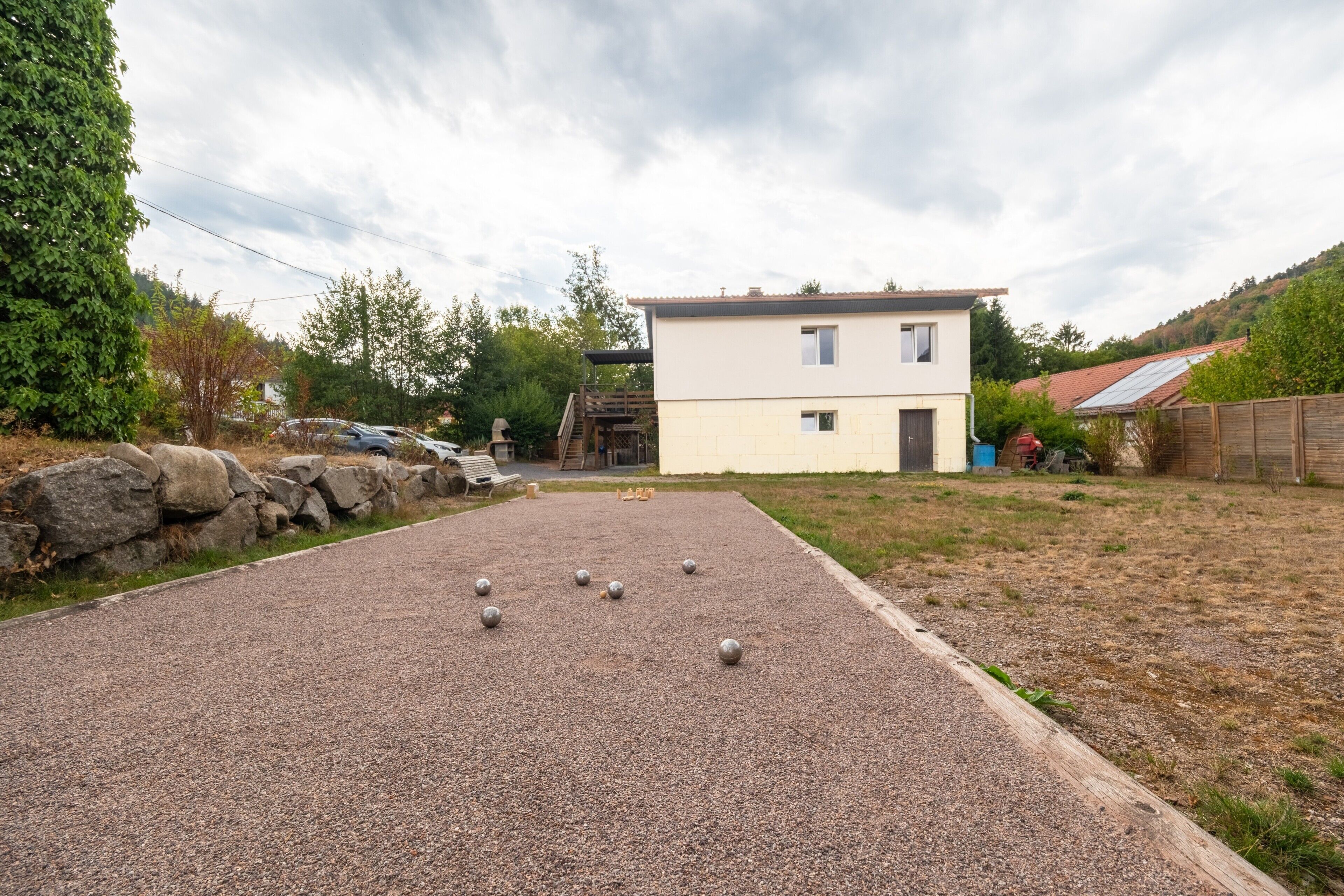 Il s’agit d’une propriété résidentielle dotée d’une cour en gravier, d’une maison blanche et d’une clôture en bois.