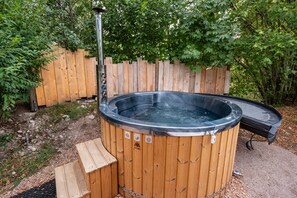 A wooden hot tub with a metal frame and a wooden deck.