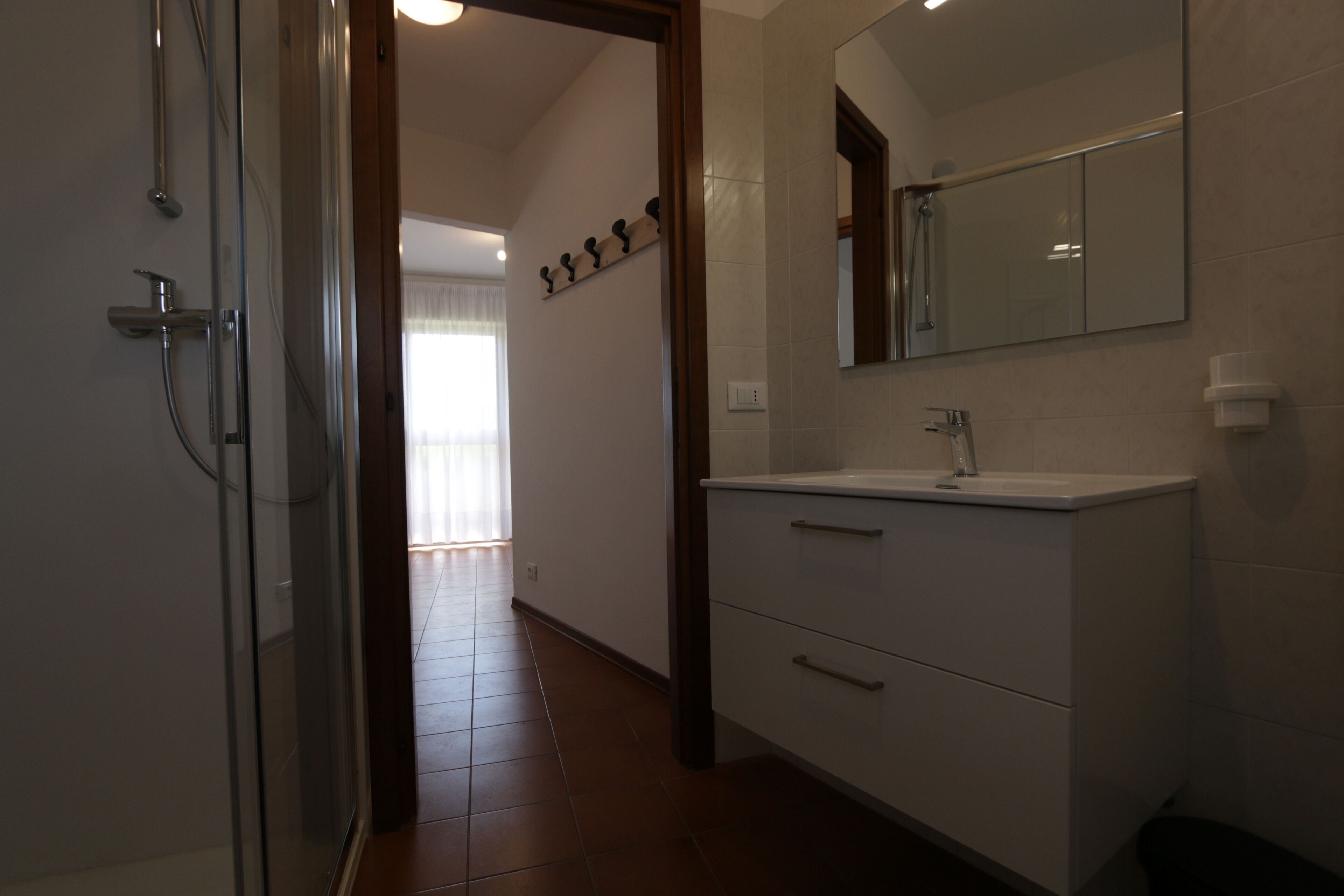 A bathroom with a shower, a sink, and a mirror.