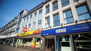Ein Geschäftsgebäude mit Schaufenstern, darunter ein LEGO-Laden, Steinzeit Hamburg und Otto Lemke Immobilien.
