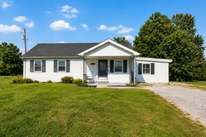 A single-story house with a front porch, a small attached garage, and a well-maintained lawn.
