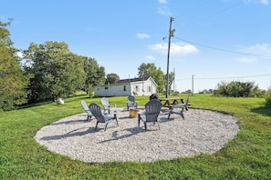 A house with a gravel patio, outdoor seating, and a fire pit.