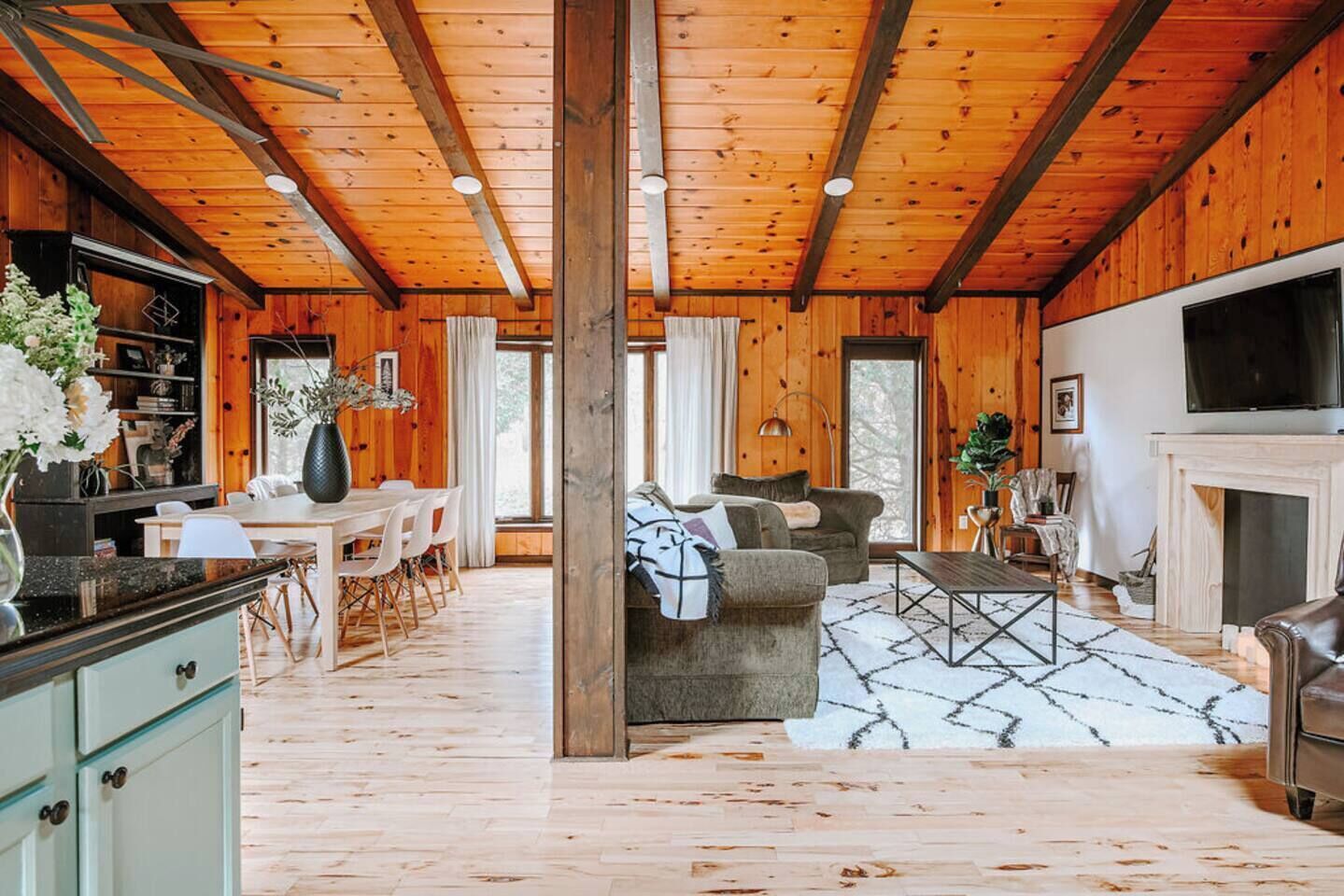 A spacious living area with a fireplace, a dining area, and a kitchen with wooden cabinets.