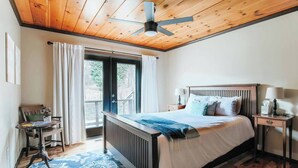 A bedroom with a bed, bedside tables, a window, and a ceiling fan.