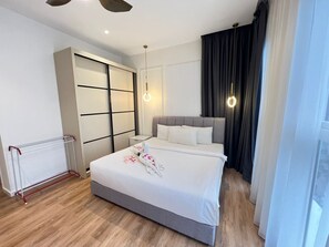 Une chambre d’hôtel avec un lit, une armoire, un radiateur et une fenêtre avec des rideaux.