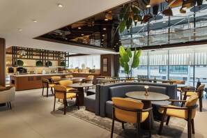 A modern interior with a bar area, seating arrangements, and large windows. - Four Points By Sheraton Diyarbakir (Diyarbakir)