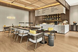 Un área de bar moderna con un panel de menú que enumera diversas bebidas.