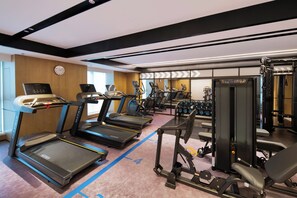 A gym with treadmills, weight machines, and a wall clock. - ​Four Points By Sheraton Linyi City Center (Linyi)