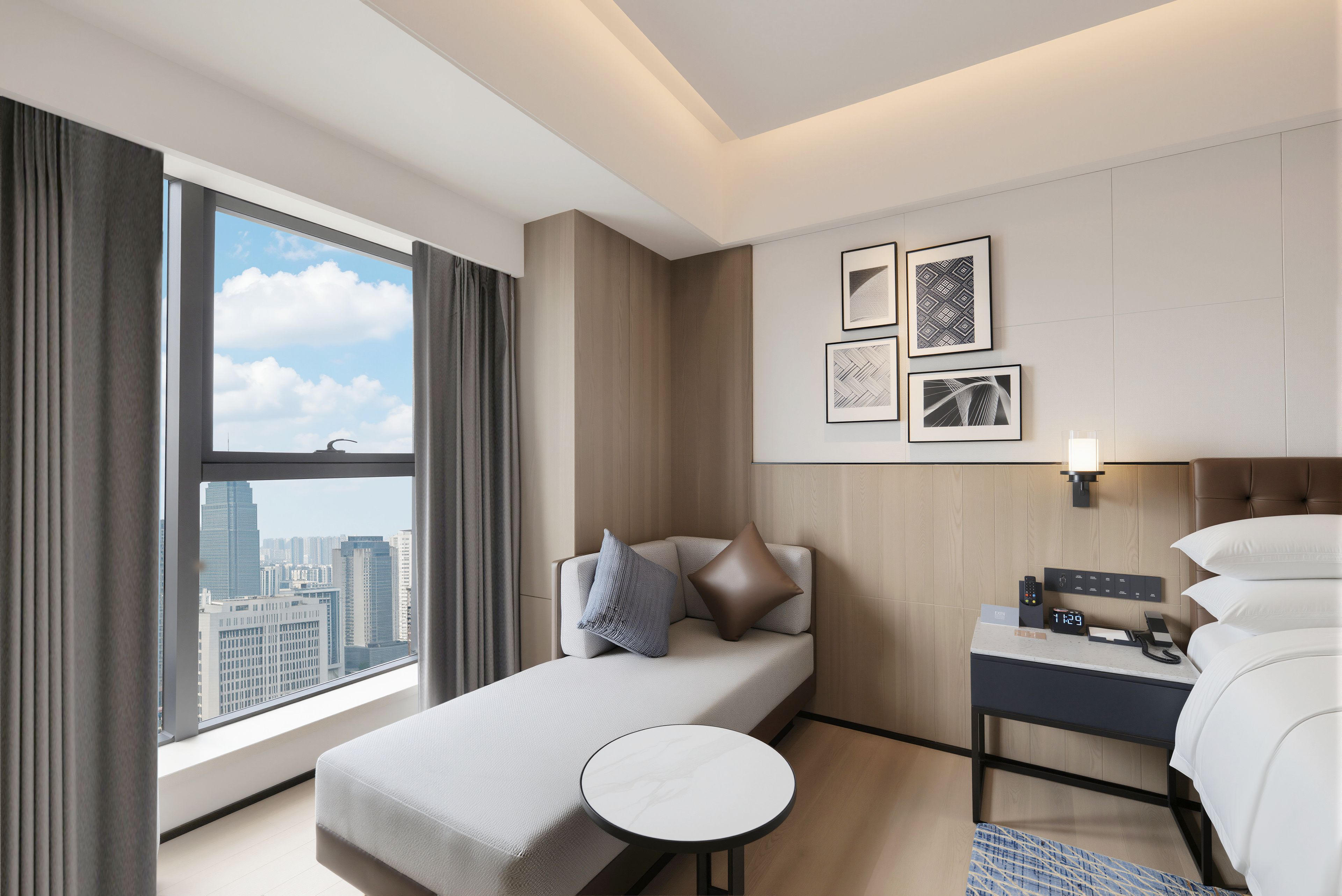 Una habitación de hotel con cama, una mesita, una mesita de noche y vistas a la ciudad.