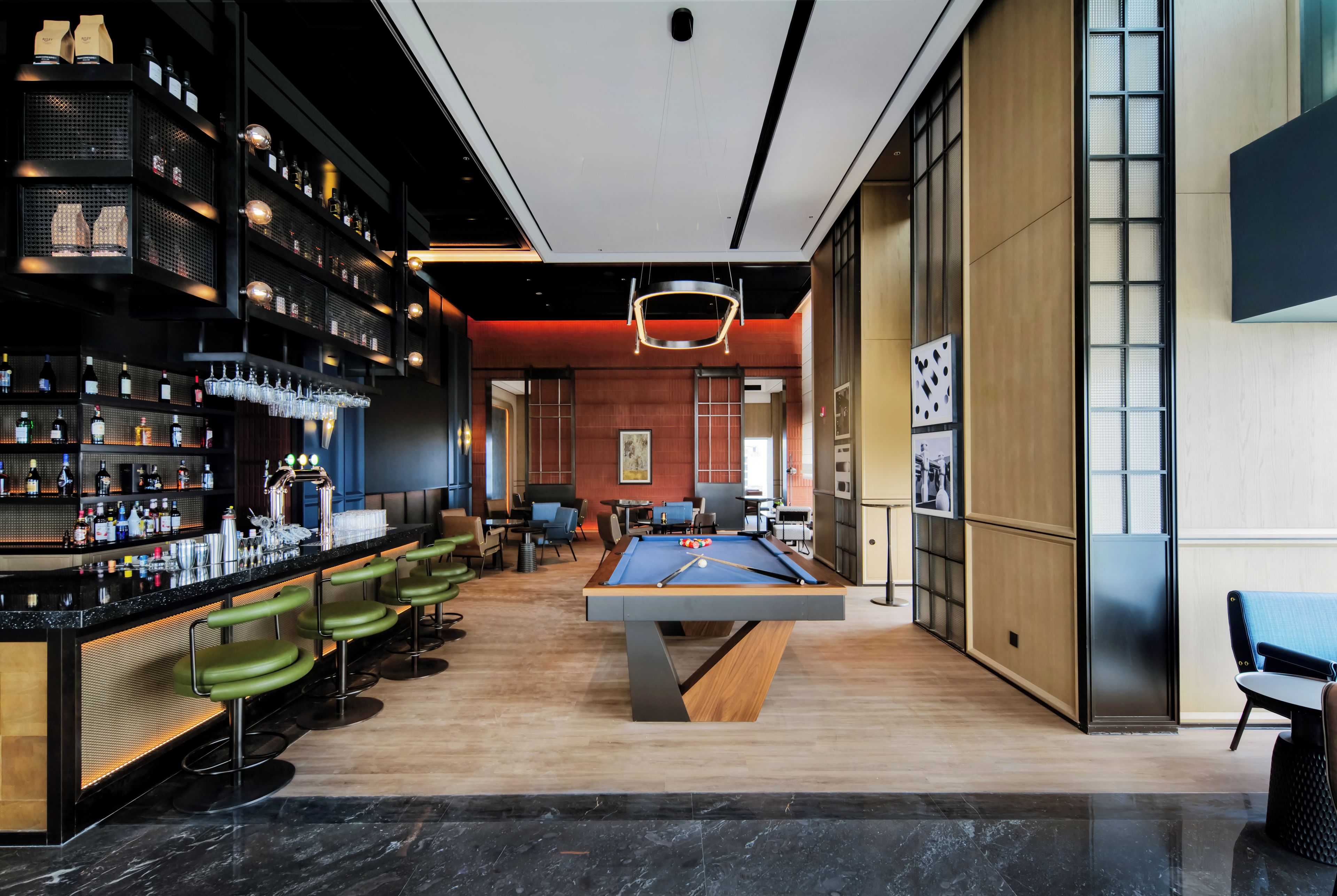 A bar area with a pool table and seating.