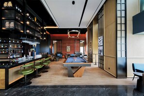 A bar area with a pool table and seating.