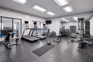 A modern gym with treadmills, weight machines, and a variety of fitness equipment.