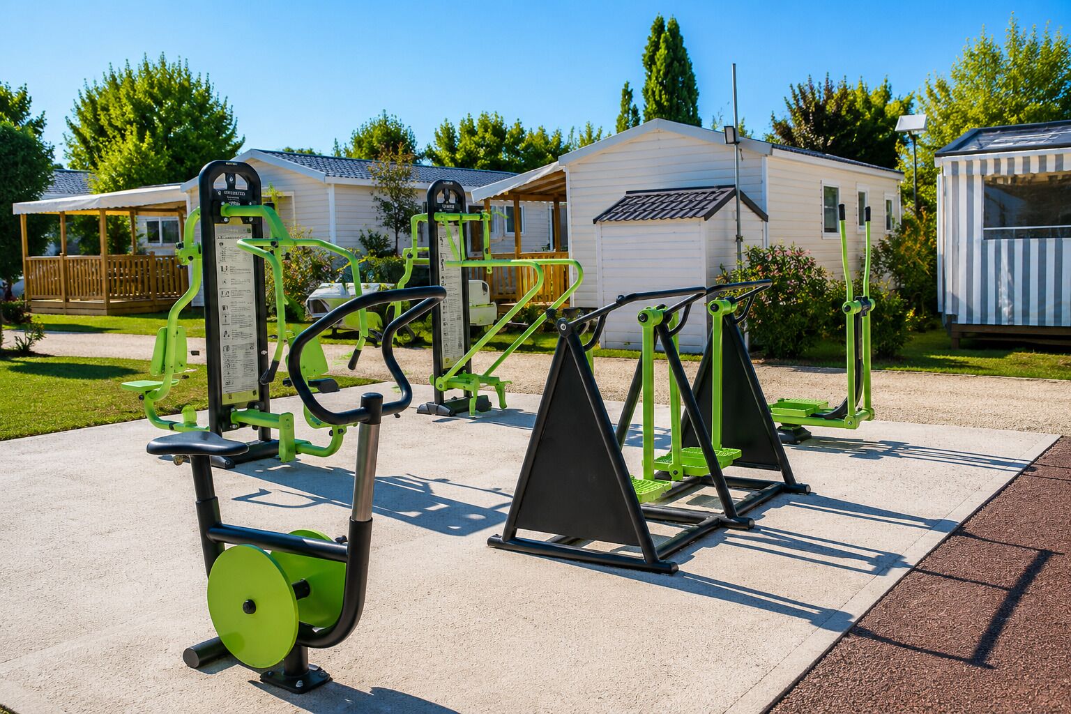 Des appareils de musculation en plein air, un espace de repos abrité et un petit bâtiment doté d’un toit en pente.