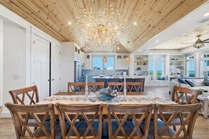 A spacious kitchen with a central island, wooden ceiling, and a view to the outside. - Blue Haven Retreat – Coastal Luxury Steps to Beach (Port Aransas)