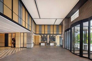 A spacious lobby with a high ceiling, large windows, and a central reception area.