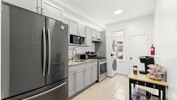 A modern kitchen with stainless steel appliances, a microwave, oven, and a coffee maker.