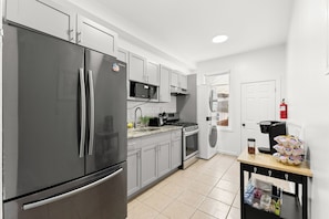 A modern kitchen with stainless steel appliances, a microwave, oven, and a coffee maker.