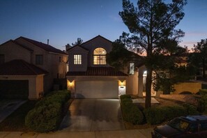 A residential house with a garage, a driveway, and a well-maintained lawn. - Pool + Hot Tub l Game Room l 20 Min to the Strip (Henderson)