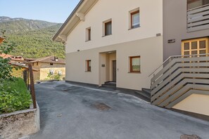 Un bâtiment moderne doté d’un toit plat, d’un escalier et offrant une vue sur un paysage montagneux.