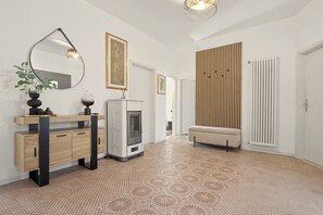 A modern interior with a wooden cabinet, a mirror, a fireplace, a bench, and a patterned floor. - Apartment 'Casa Elda' with Mountain View, Balcony and Wi-Fi (Vigo di Ton)
