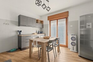 Eine moderne Küche mit grauen Schränken, einem Holztisch und einem eingebauten Backofen.