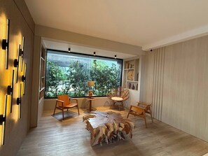 A modern interior with a large window, wooden flooring, and a central seating area with a unique wooden coffee table. - Modern retreat in Novo Campeche, 100m from the beach! (Florianópolis)