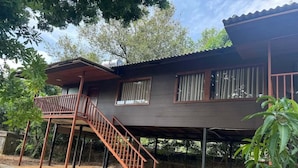 Una casa de madera de dos pisos con balcón y escalera.