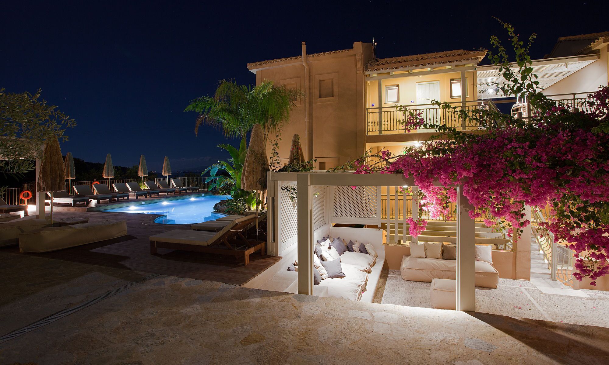 A pool area with lounge chairs and a covered seating area.
