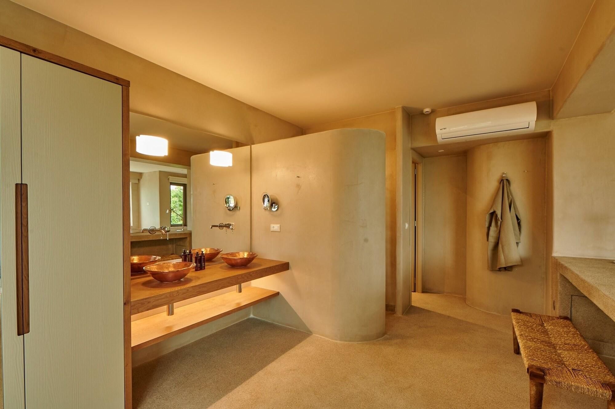 A bathroom with a wooden vanity, a large mirror, and a towel rack.
