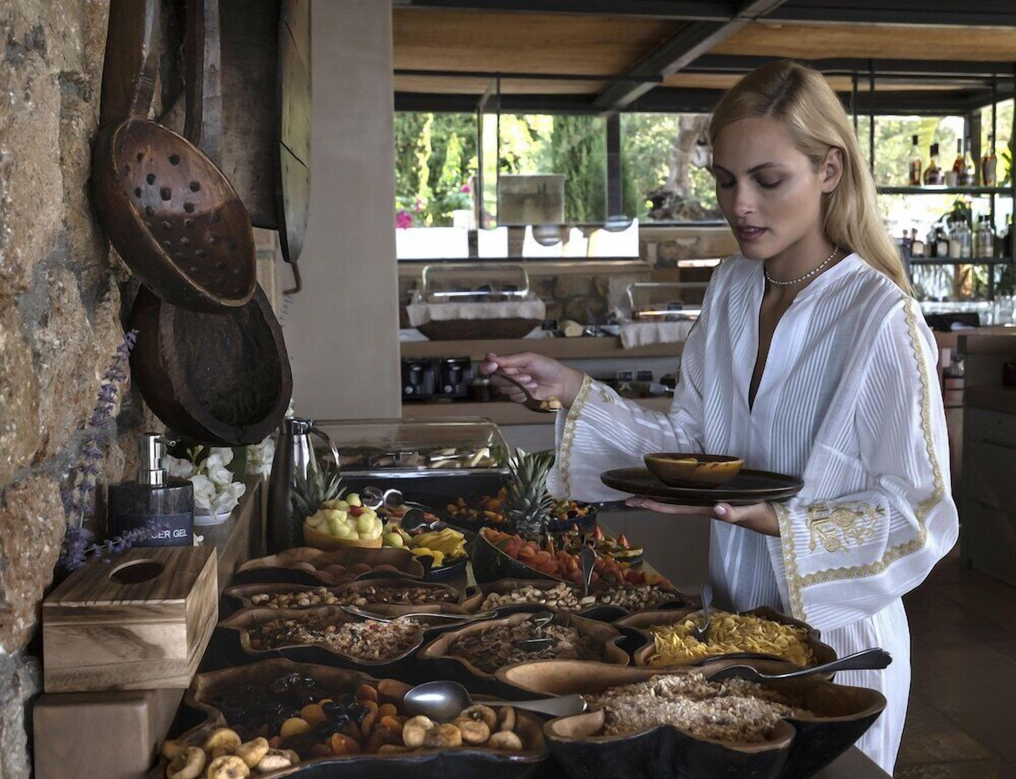 A buffet setup with various food items and a person serving.