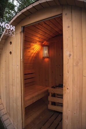 A wooden sauna with a bench and a slanted ceiling. - Charming Tiny House by the Lake with a Sauna (Kloster Lehnin)