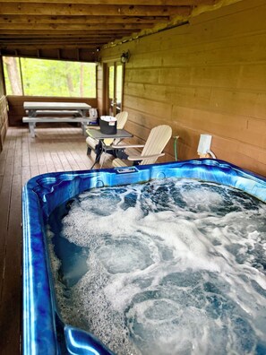 Ein Whirlpool mit einer Holzterrasse und Sitzbereich.