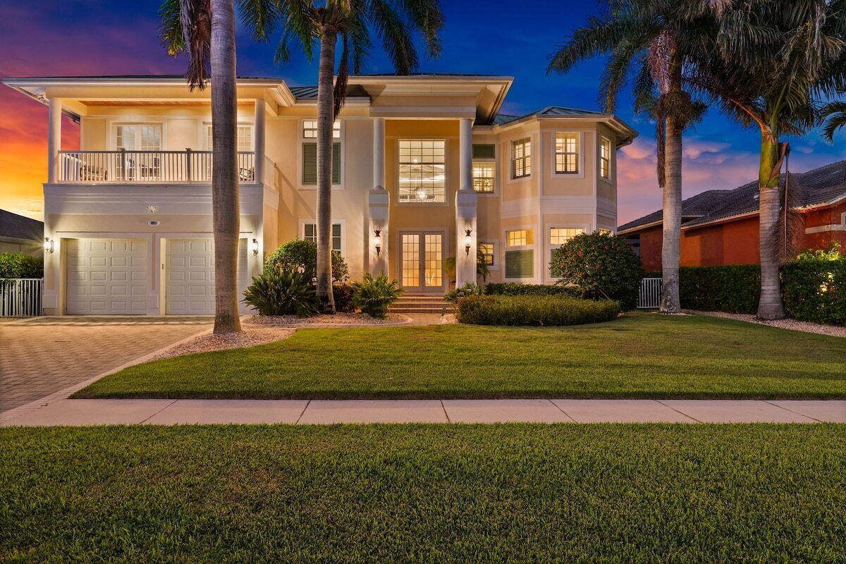 A two-story house with a front entrance, a garage, and a well-maintained lawn.
