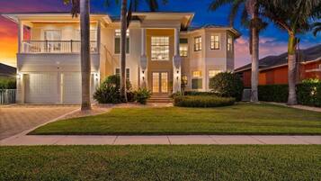 A two-story house with a front entrance, a garage, and a well-maintained lawn.