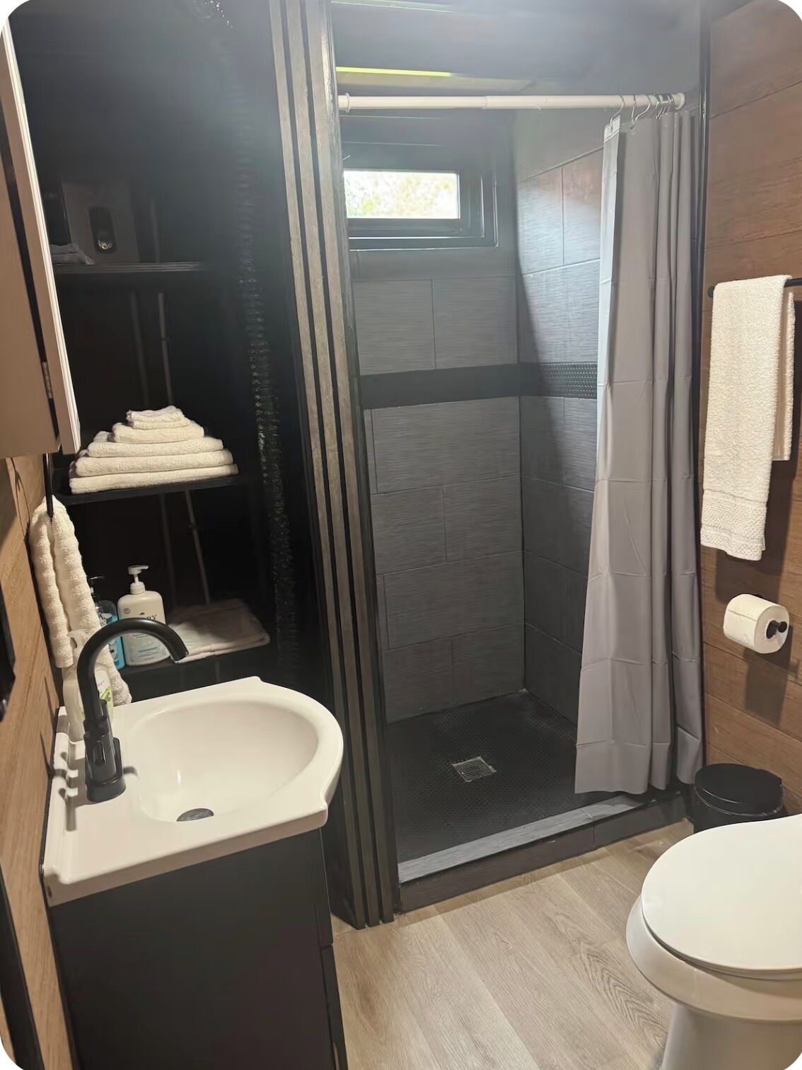 Un baño moderno con ducha, inodoro y lavabo.