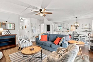 A spacious living room with a blue sofa, two armchairs, a coffee table, and a ceiling fan. - Waterfront Condo | King Bed | Walk to Douglas (Douglas)